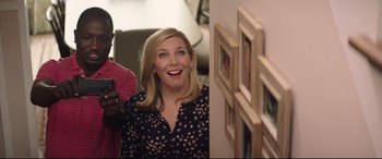 Movie still from “Blockers” (2018), directed by Kay Cannon – A woman standing next to a wall in a living room; Medium shot, Over the shoulder angle