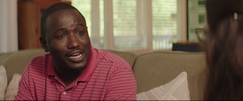 Movie still from “Blockers” (2018), directed by Kay Cannon – A person sitting on a couch in a living room; Close Up shot, Over the shoulder angle