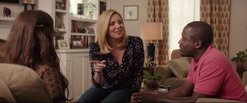 Movie still from “Blockers” (2018), directed by Kay Cannon – A woman sitting on a couch in a living room; Medium shot, Over the shoulder angle