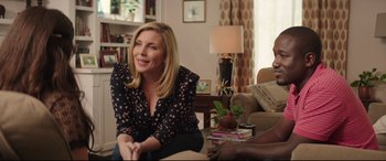 Movie still from “Blockers” (2018), directed by Kay Cannon – A woman sitting on a couch in a living room; Medium shot, Over the shoulder angle