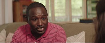 Movie still from “Blockers” (2018), directed by Kay Cannon – A person sitting on a couch in a living room; Close Up shot, Over the shoulder angle