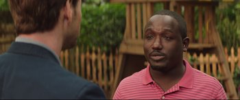 Movie still from “Blockers” (2018), directed by Kay Cannon – A man talking to another man in front of a wooden fence; Close Up shot, Over the shoulder angle