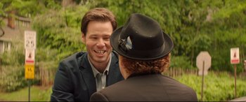 Movie still from “Blockers” (2018), directed by Kay Cannon – A man in a suit and a woman in a black hat talking; Close Up shot, Over the shoulder angle