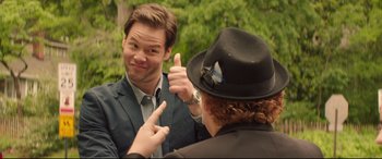 Movie still from “Blockers” (2018), directed by Kay Cannon – A man giving a thumbs up to another man wearing a hat; Close Up shot, Over the shoulder angle