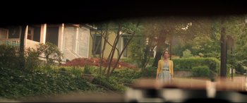 Movie still from “Blockers” (2018), directed by Kay Cannon – A woman standing in front of a house in a yard; Wide shot, Over the shoulder angle