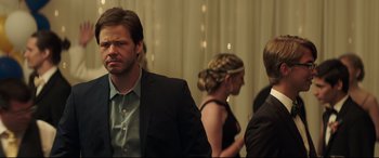 Movie still from “Blockers” (2018), directed by Kay Cannon – A man in a black suit and a woman in a black dress; Close Up shot, Over the shoulder angle