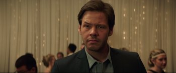 Movie still from “Blockers” (2018), directed by Kay Cannon – A person wearing a suit and tie; Close Up shot, Over the shoulder angle