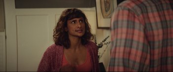 Movie still from “Blockers” (2018), directed by Kay Cannon – A young woman with long curly brown hair wearing a pink shirt; Medium shot, Over the shoulder angle