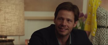 Movie still from “Blockers” (2018), directed by Kay Cannon – A person wearing a suit and smiling; Close Up shot, Over the shoulder angle