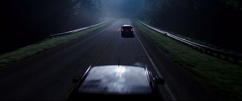 Movie still from “Blockers” (2018), directed by Kay Cannon – A car driving down a street at night; Wide shot, High angle