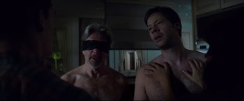 Movie still from “Blockers” (2018), directed by Kay Cannon – A man with a blindfold and a man with a hand on his chest; Medium shot, Over the shoulder angle