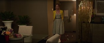 Movie still from “Blockers” (2018), directed by Kay Cannon – A woman standing in front of a mirror in a room; Wide shot, High angle