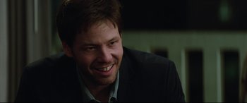 Movie still from “Blockers” (2018), directed by Kay Cannon – A person wearing a suit and smiling; Close Up shot, Over the shoulder angle