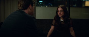 Movie still from “Blockers” (2018), directed by Kay Cannon – A young man and a young woman sitting on a brown couch; Medium shot, Over the shoulder angle