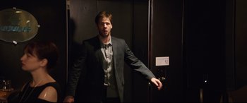 Movie still from “Blockers” (2018), directed by Kay Cannon – A man in a suit standing in front of an elevator; Medium shot, Over the shoulder angle