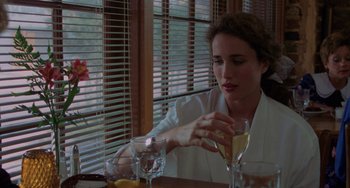 Movie still from “Sex, Lies, and Videotape” (1989), directed by Steven Soderbergh – A woman sitting at a table with a glass of wine; Close Up shot, Over the shoulder angle
