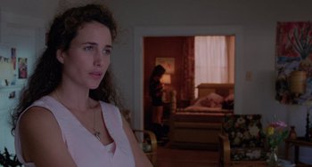 Movie still from “Sex, Lies, and Videotape” (1989), directed by Steven Soderbergh – A woman standing in front of a bed in a living room; Medium shot, Over the shoulder angle