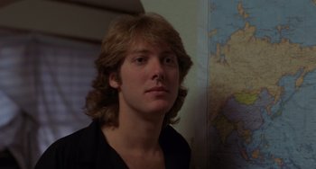 Movie still from “Sex, Lies, and Videotape” (1989), directed by Steven Soderbergh – A man with long blonde hair standing in front of a map; Close Up shot, Over the shoulder angle