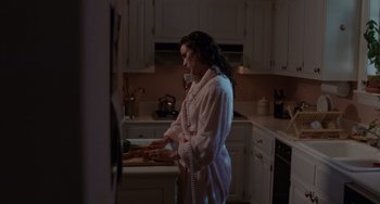 Movie still from “Sex, Lies, and Videotape” (1989), directed by Steven Soderbergh – A woman standing in a kitchen preparing a meal; Medium shot, High angle
