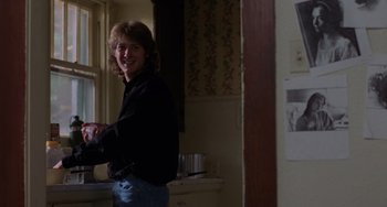 Movie still from “Sex, Lies, and Videotape” (1989), directed by Steven Soderbergh – A man standing in a kitchen next to a counter; Medium shot, Over the shoulder angle