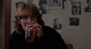 Movie still from “Sex, Lies, and Videotape” (1989), directed by Steven Soderbergh – A man drinking a glass of beer in a room; Close Up shot, Over the shoulder angle