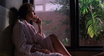Movie still from “Sex, Lies, and Videotape” (1989), directed by Steven Soderbergh – A woman sitting on a chair talking on a phone; Medium shot, Low angle