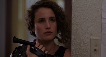 Movie still from “Sex, Lies, and Videotape” (1989), directed by Steven Soderbergh – A woman holding a remote control in her hand; Close Up shot, Over the shoulder angle