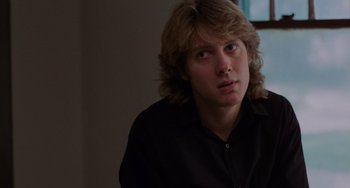 Movie still from “Sex, Lies, and Videotape” (1989), directed by Steven Soderbergh – A man with long blonde hair wearing a black shirt; Close Up shot, Over the shoulder angle