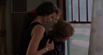 Movie still from “Sex, Lies, and Videotape” (1989), directed by Steven Soderbergh – A woman is holding a man's arm in front of a window; Medium shot, Over the shoulder angle