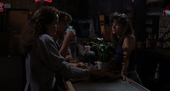 Movie still from “Sex, Lies, and Videotape” (1989), directed by Steven Soderbergh – A group of people sitting at a table in front of a potted plant; Medium shot, Over the shoulder angle