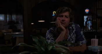 Movie still from “Sex, Lies, and Videotape” (1989), directed by Steven Soderbergh – A man sitting at a table with a cigarette in his mouth; Medium shot, Low angle