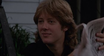 Movie still from “Sex, Lies, and Videotape” (1989), directed by Steven Soderbergh – A young man with long hair is smiling for the camera; Close Up shot, Low angle