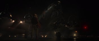 Movie still from “Shadow in the Cloud” (2020), directed by Roseanne Liang – An airplane is parked on the runway at night; Wide shot, Low angle