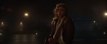 Movie still from “Shadow in the Cloud” (2020), directed by Roseanne Liang – A woman in a brown leather jacket holding a brown bag; Medium shot, Low angle