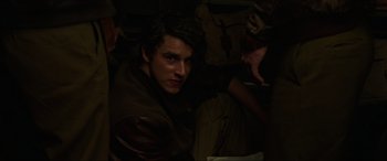 Movie still from “Shadow in the Cloud” (2020), directed by Roseanne Liang – A young man is sitting in a dark room; Close Up shot, High angle