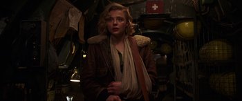 Movie still from “Shadow in the Cloud” (2020), directed by Roseanne Liang – A woman in a brown jacket and a white scarf; Medium shot, Low angle