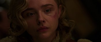 Movie still from “Shadow in the Cloud” (2020), directed by Roseanne Liang – A person with a bruise on their face; Close Up shot, High angle