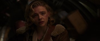 Movie still from “Shadow in the Cloud” (2020), directed by Roseanne Liang – A young woman in a brown jacket looking at the camera; Close Up shot, Over the shoulder angle