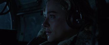 Movie still from “Shadow in the Cloud” (2020), directed by Roseanne Liang – A person wearing headphones; Close Up shot, Low angle