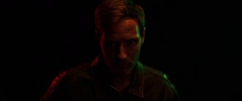 Movie still from “Shadow in the Cloud” (2020), directed by Roseanne Liang – A man in a dark room with green light; Close Up shot, Low angle