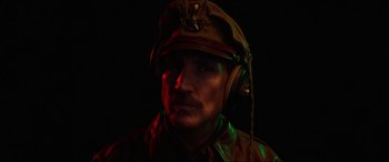 Movie still from “Shadow in the Cloud” (2020), directed by Roseanne Liang – A man in a military uniform wearing headphones; Close Up shot, Low angle
