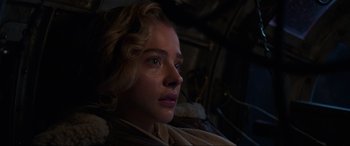 Movie still from “Shadow in the Cloud” (2020), directed by Roseanne Liang – A young woman is sitting in the dark; Close Up shot, Low angle