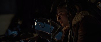 Movie still from “Shadow in the Cloud” (2020), directed by Roseanne Liang – A young girl is looking at the camera through a lens; Close Up shot, Low angle