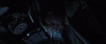 Movie still from “Shadow in the Cloud” (2020), directed by Roseanne Liang – A woman is looking at the camera in a dark room; Close Up shot, Low angle