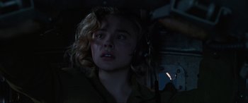 Movie still from “Shadow in the Cloud” (2020), directed by Roseanne Liang – A young girl with headphones looking up at the sky; Close Up shot, Low angle