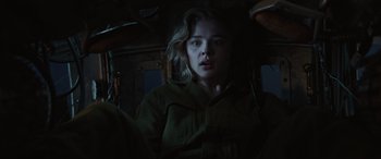 Movie still from “Shadow in the Cloud” (2020), directed by Roseanne Liang – A woman with blonde hair is standing in a dark room; Close Up shot, High angle