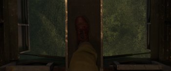 Movie still from “Shadow in the Cloud” (2020), directed by Roseanne Liang – A person standing on a slide at night time; Extreme Close Up shot, Overhead angle