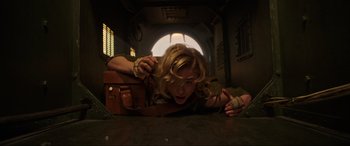 Movie still from “Shadow in the Cloud” (2020), directed by Roseanne Liang – A woman is laying on the ground with a suitcase; Medium shot, Overhead angle
