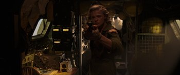 Movie still from “Shadow in the Cloud” (2020), directed by Roseanne Liang – A man holding a gun while standing in a room; Medium shot, Low angle