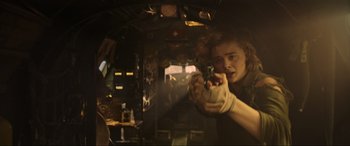 Movie still from “Shadow in the Cloud” (2020), directed by Roseanne Liang – A person holding a gun in a room; Medium shot, Low angle